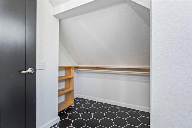 spacious closet with dark tile patterned floors