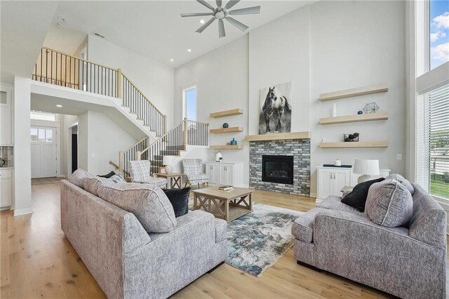 1312 NW 107th Ter, Kansas City, MO 64155 - living room with a towering ceiling, healthy amount of natural light, a ceiling fan, stairs, and light wood-type flooring