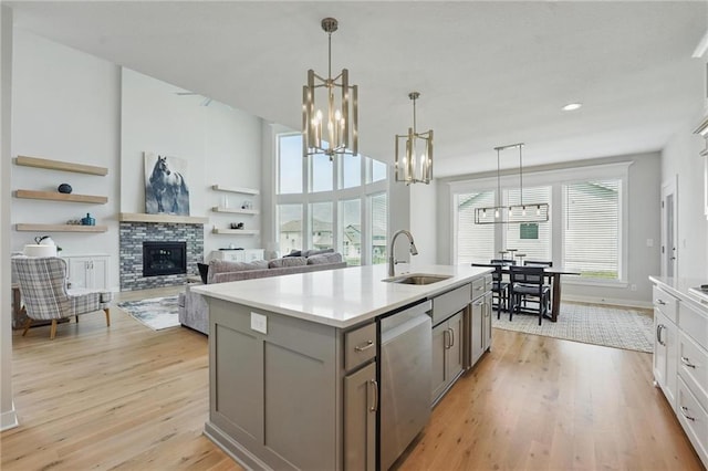 1312 NW 107th Ter, Kansas City, MO 64155 - kitchen with a sink, a chandelier, dishwasher, gray cabinetry, and light wood finished floors