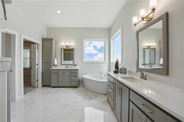 1312 NW 107th Ter, Kansas City, MO 64155 - full bath with a freestanding tub, marble finish floors, two vanities, and baseboards