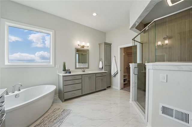 1312 NW 107th Ter, Kansas City, MO 64155 - bathroom with marble look tile flooring, a stall shower, vanity, a freestanding tub, and baseboards
