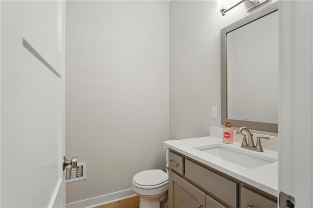 1312 NW 107th Ter, Kansas City, MO 64155 - bathroom featuring vanity, toilet, wood finished floors, and baseboards