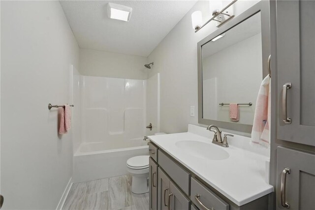 1312 NW 107th Ter, Kansas City, MO 64155 - full bathroom with toilet, vanity, shower / bath combination, marble look tiles, and a textured ceiling