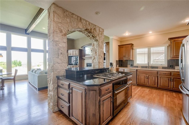 kitchen with light wood-type flooring, brown cabinetry, and stainless steel appliances