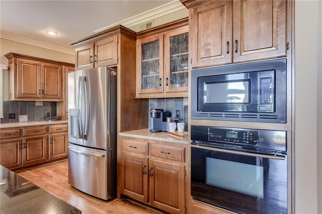 kitchen with tasteful backsplash, built in microwave, stainless steel fridge, ornamental molding, and oven