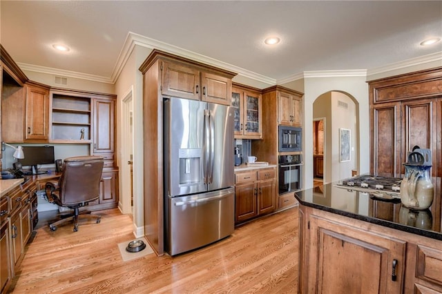 kitchen featuring brown cabinets, open shelves, light wood-style floors, arched walkways, and black appliances