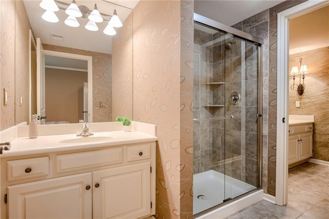 full bathroom featuring vanity, tile patterned floors, wallpapered walls, visible vents, and a stall shower
