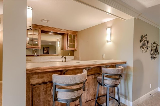bar with baseboards, visible vents, and ornamental molding