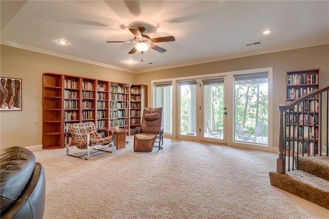sitting room featuring visible vents, crown molding, baseboards, ceiling fan, and carpet