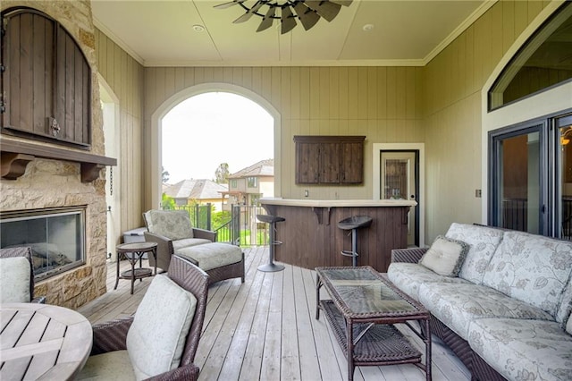 exterior space with ceiling fan, outdoor dry bar, and an outdoor living space with a fireplace