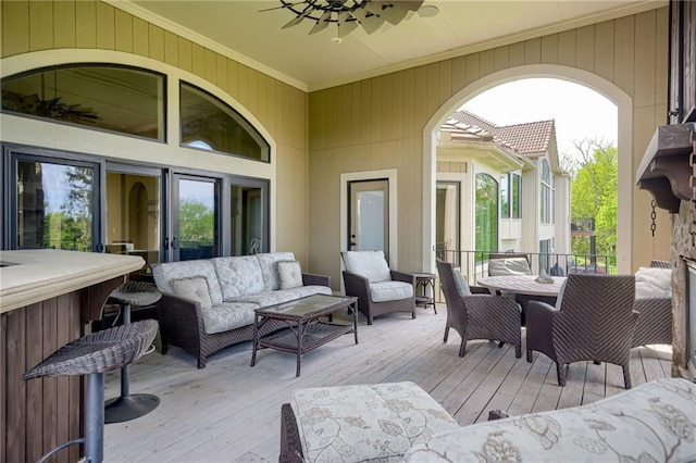 wooden deck with outdoor dining space, ceiling fan, and an outdoor living space