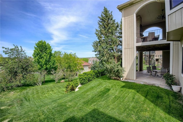 view of yard with stairs, a patio area, and a balcony