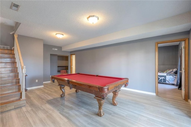 rec room featuring a textured ceiling, light wood-style flooring, pool table, baseboards, and visible vents