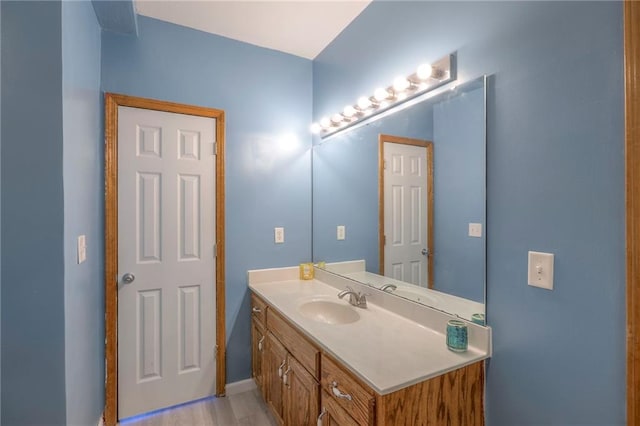 bathroom with vanity, baseboards, and wood finished floors