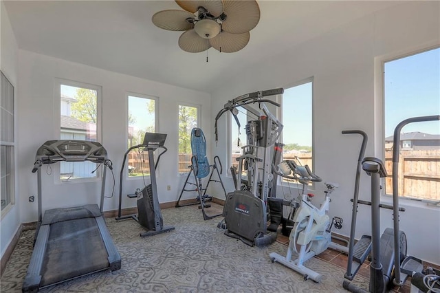 exercise area featuring baseboards, ceiling fan, carpet, and lofted ceiling