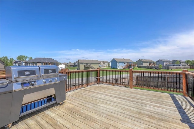 wooden deck featuring area for grilling, fence, and a residential view