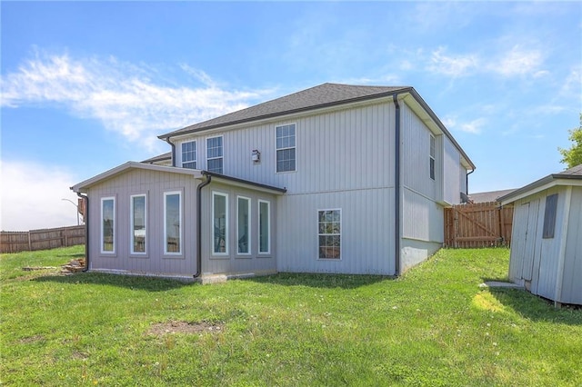 rear view of property with a fenced backyard and a yard