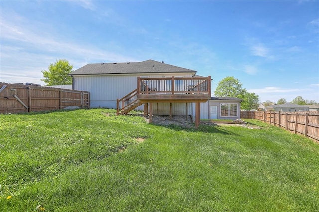 back of property with a yard, a deck, a fenced backyard, and stairs