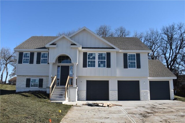 6022 NE 118th Ter, Kansas City, MO 64156 - bi-level home featuring board and batten siding, a shingled roof, driveway, and an attached garage