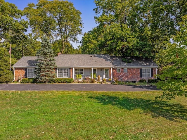 single story home featuring asphalt driveway, a front yard, and brick siding