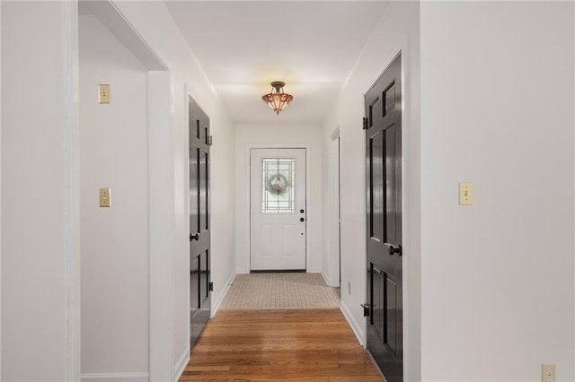 entryway featuring baseboards and light wood-style floors