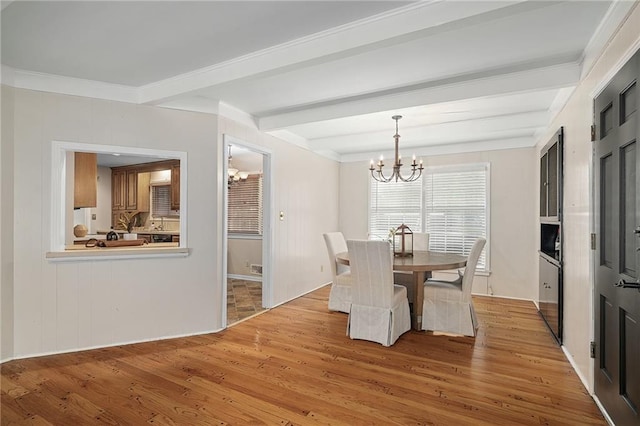 dining room featuring a chandelier, beam ceiling, light wood-style floors, and crown molding