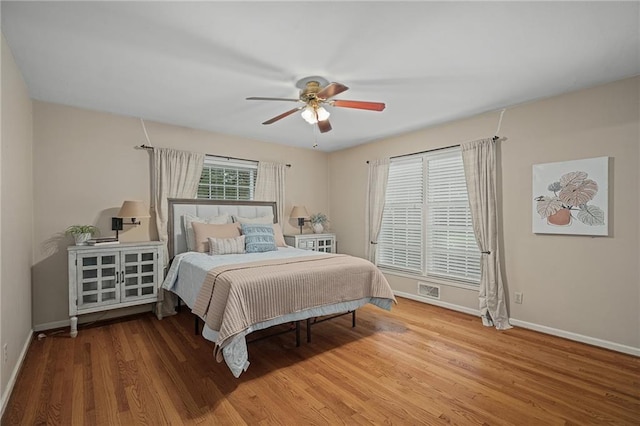 bedroom with baseboards, wood finished floors, and a ceiling fan