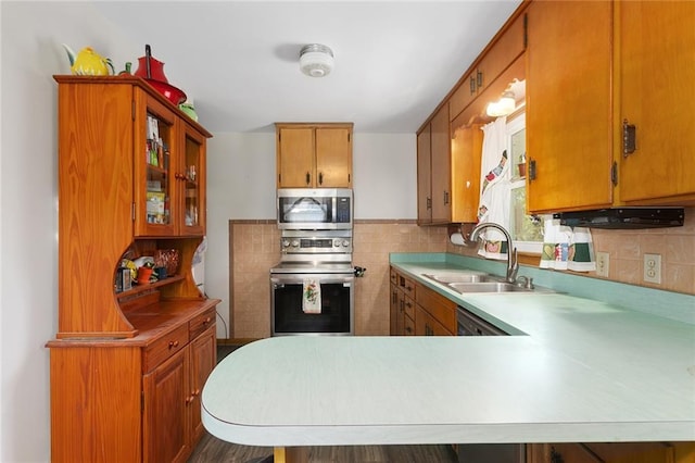 9382 N Cookingham Dr, Kansas City, MO 64157 - kitchen featuring brown cabinets, light countertops, a sink, glass insert cabinets, and appliances with stainless steel finishes