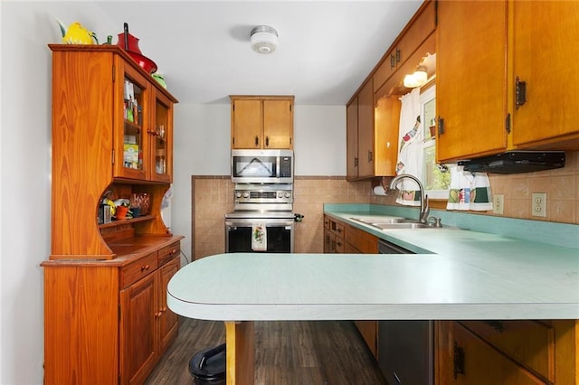 9382 N Cookingham Dr, Kansas City, MO 64157 - kitchen featuring stainless steel appliances, light countertops, a sink, brown cabinetry, and dark wood-style flooring
