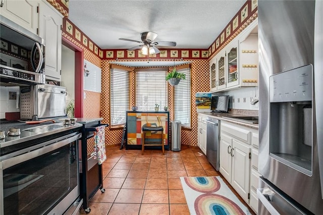5103 S Shrank Ave, Independence, MO 64055 - kitchen featuring ceiling fan, a sink, stainless steel appliances, wallpapered walls, and white cabinetry