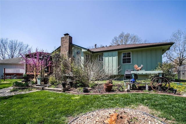 5103 S Shrank Ave, Independence, MO 64055 - back of house featuring board and batten siding, fence, a yard, and a chimney
