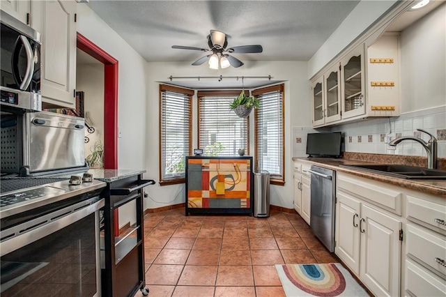 5103 S Shrank Ave, Independence, MO 64055 - kitchen featuring ceiling fan, appliances with stainless steel finishes, a sink, baseboards, and tasteful backsplash