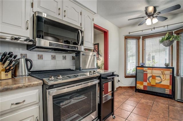 5103 S Shrank Ave, Independence, MO 64055 - kitchen with decorative backsplash, white cabinetry, ceiling fan, and stainless steel appliances