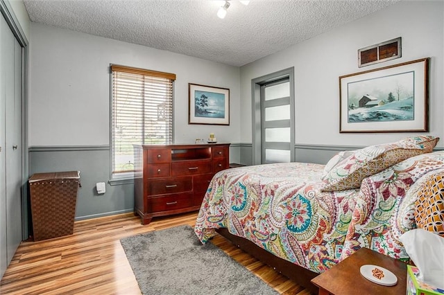 5103 S Shrank Ave, Independence, MO 64055 - bedroom with light wood finished floors, a textured ceiling, baseboards, visible vents, and a closet