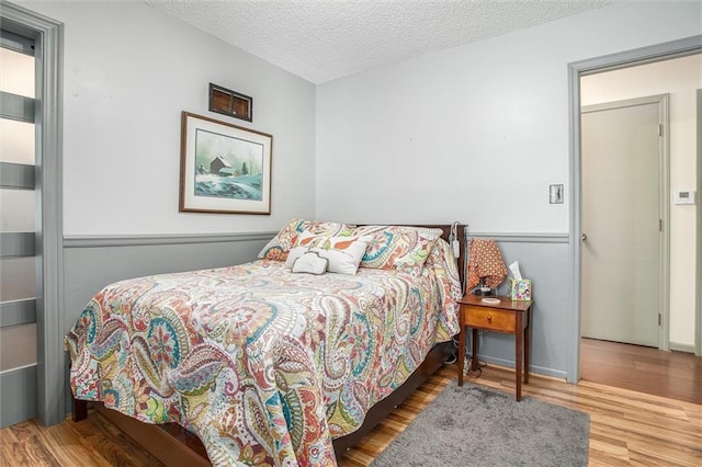 5103 S Shrank Ave, Independence, MO 64055 - bedroom with baseboards, a textured ceiling, and wood finished floors