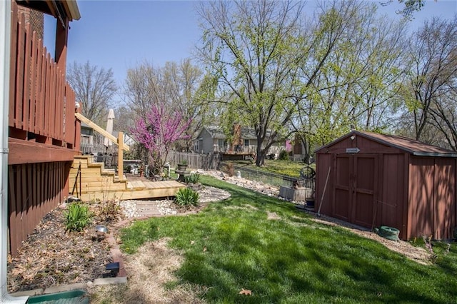 5103 S Shrank Ave, Independence, MO 64055 - view of yard featuring an outdoor structure, a fenced backyard, a shed, and a wooden deck