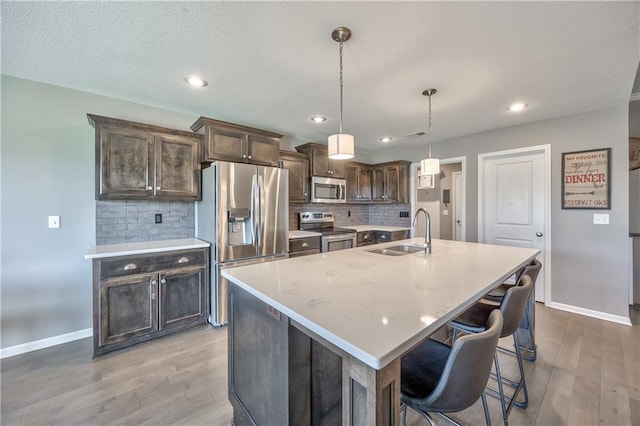 4246 Lakeview Ter, Basehor, KS 66007 - kitchen with light wood-type flooring, baseboards, a sink, and appliances with stainless steel finishes