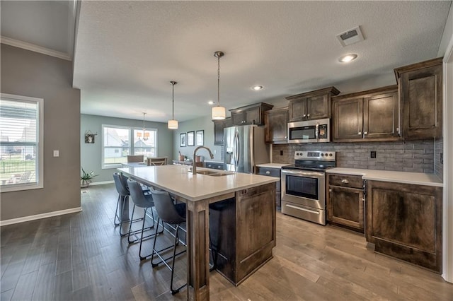 4246 Lakeview Ter, Basehor, KS 66007 - kitchen with a kitchen breakfast bar, stainless steel appliances, light countertops, visible vents, and a sink