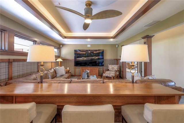 101 Algonquin Dr, Lake Winnebago, MO 64034 - living area featuring a raised ceiling, a ceiling fan, and a wainscoted wall