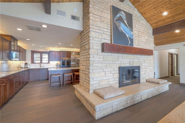 101 Algonquin Dr, Lake Winnebago, MO 64034 - kitchen with appliances with stainless steel finishes, high vaulted ceiling, wood ceiling, a kitchen breakfast bar, and wood finished floors