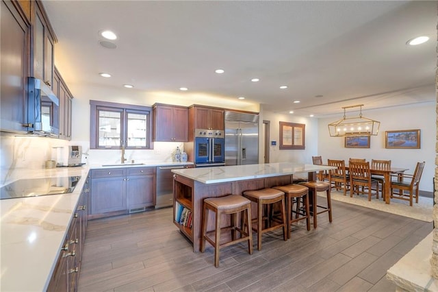 101 Algonquin Dr, Lake Winnebago, MO 64034 - kitchen featuring appliances with stainless steel finishes, a sink, dark wood-style floors, a breakfast bar, and recessed lighting