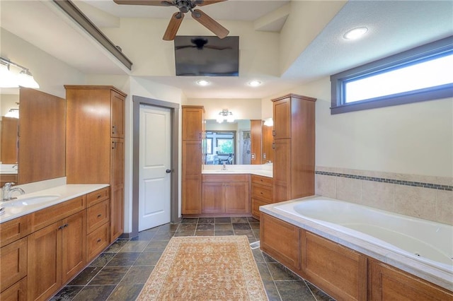 101 Algonquin Dr, Lake Winnebago, MO 64034 - bathroom with a garden tub, two vanities, ceiling fan, stone tile flooring, and recessed lighting