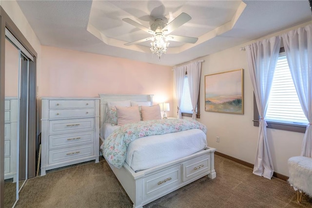 101 Algonquin Dr, Lake Winnebago, MO 64034 - bedroom featuring a raised ceiling, dark carpet, ceiling fan, baseboards, and a closet