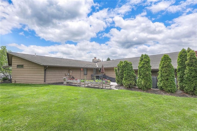 101 Algonquin Dr, Lake Winnebago, MO 64034 - back of house featuring a lawn, a chimney, and a vegetable garden