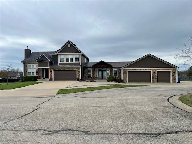 908 Cedar Ct, Paola, KS 66071 - view of front of home featuring driveway, a chimney, an attached garage, and stone siding