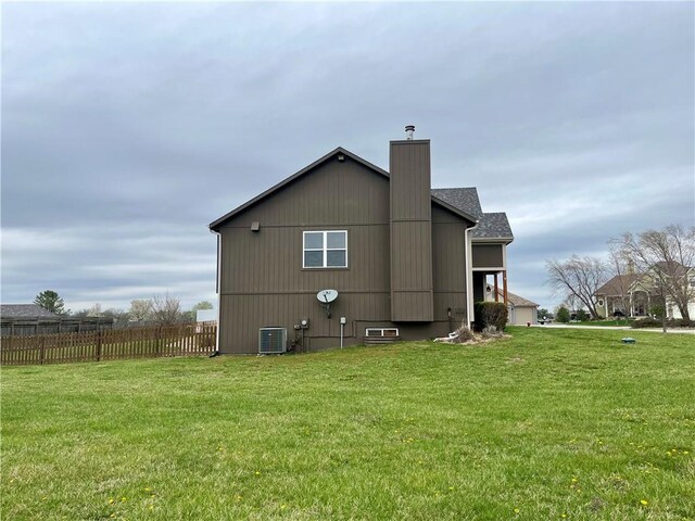 908 Cedar Ct, Paola, KS 66071 - back of house with a chimney and central air condition unit