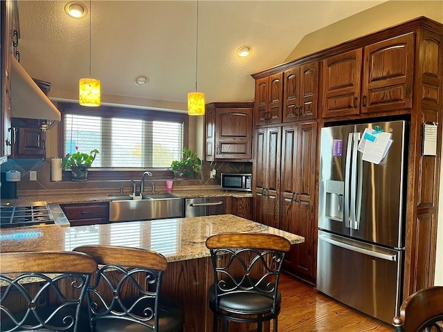 908 Cedar Ct, Paola, KS 66071 - kitchen with stainless steel appliances, a sink, a breakfast bar, tasteful backsplash, and decorative light fixtures