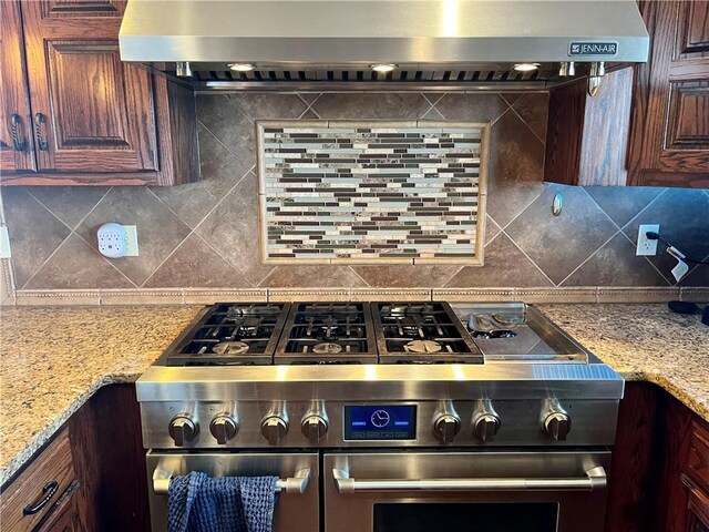 908 Cedar Ct, Paola, KS 66071 - kitchen with double oven range, wall chimney range hood, backsplash, and light stone countertops