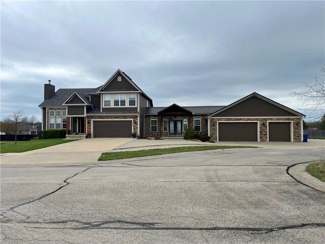 908 Cedar Ct, Paola, KS 66071 - view of front of property featuring concrete driveway, stone siding, and a chimney