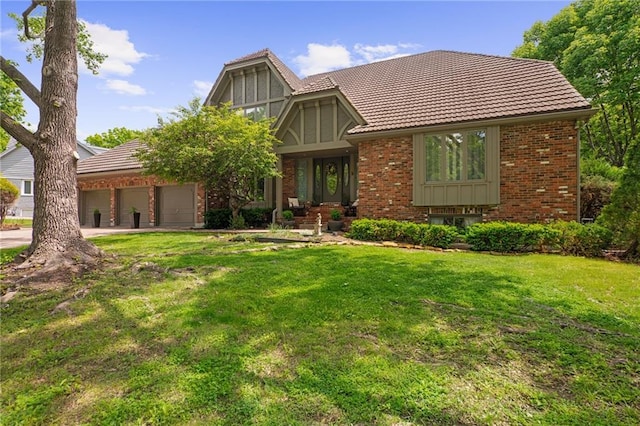 3705 W 119th Ter, Leawood, KS 66209 - tudor house featuring a tiled roof, brick siding, a front yard, an attached garage, and driveway